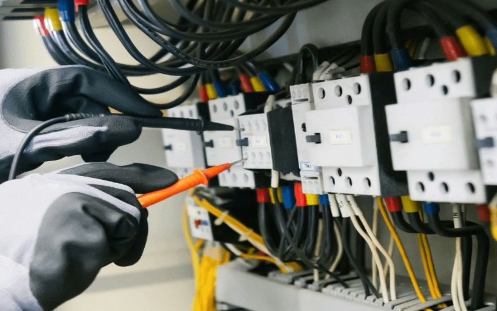 Elektriker prüft einen Verteiler mit dem Messgerät